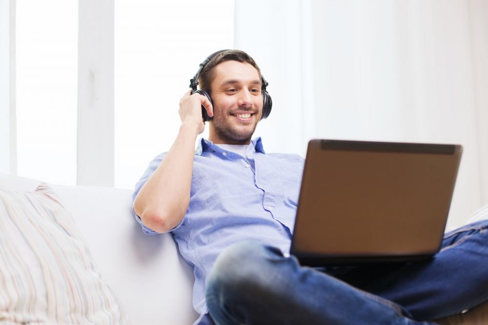 smiling-man-with-laptop-and-headphones-at-home